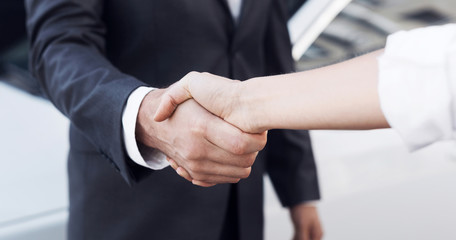 Car sale. Customer and salesman shaking hands