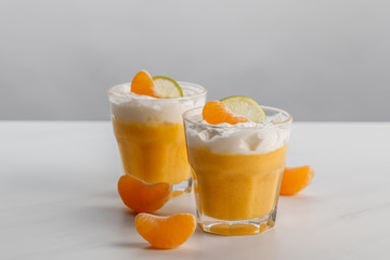two glasses with cream desserts with tangerine and lime slices