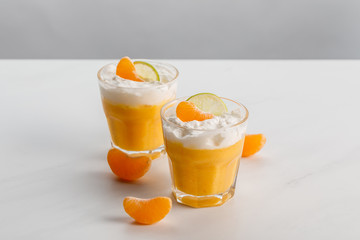 glasses with orange desserts with tangerine and lime slices