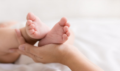 Obraz na płótnie Canvas Little baby feet in mother hands closeup
