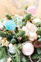many colorful lollipop on decorated Christmas tree, top view,balls, stars, cones, hearts, gold toys