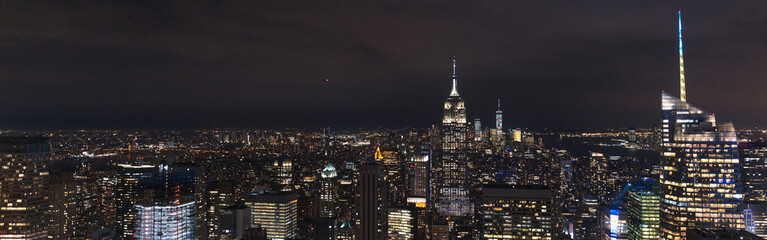 Obraz na płótnie Canvas panoramic view of buildings and night city lights in new york, usa