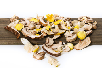 Colorful variety of exotic mushrooms on a wooden cutting board.