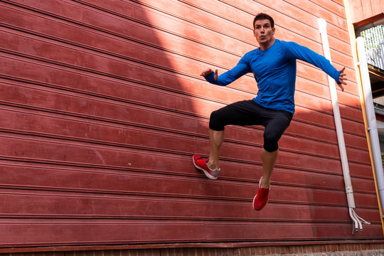 Sportive man exercising at red house