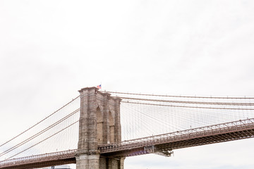 low angle view of brooklyn bridge and cloudy sky on background, new york, usa