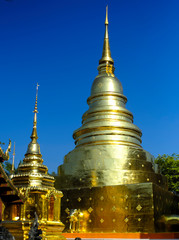 Naklejka premium Thai pagoda covered with gold cut with blue sky. 