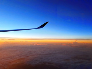 Fototapeta na wymiar an airplane wing on the beautiful blue sky in the early morning