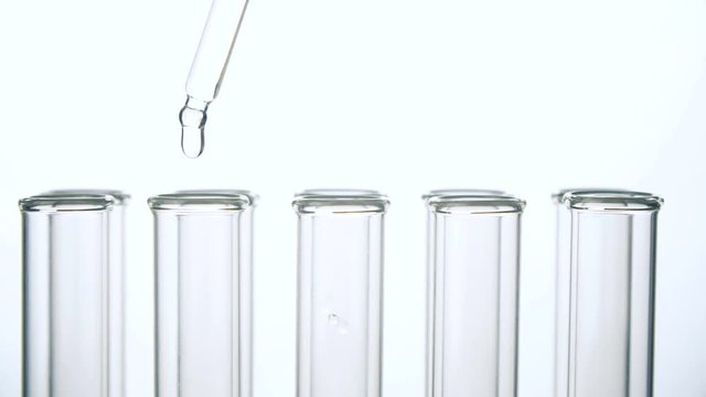 Test tubes and pipette with water drop . Close up 4k footage.