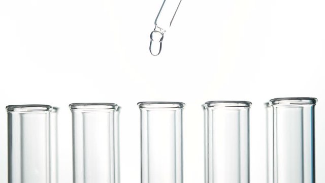 Test tubes and pipette with water drop . Close up slow motion footage.