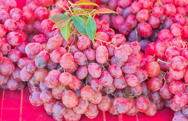 A pile of red grape fruit on red cloth for sale in the local market in Thailand.