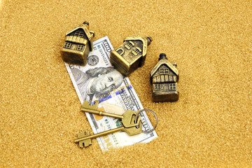 Dollars, houses, keys on the sea sandy shore. Concept for business, buying a home in hot countries.