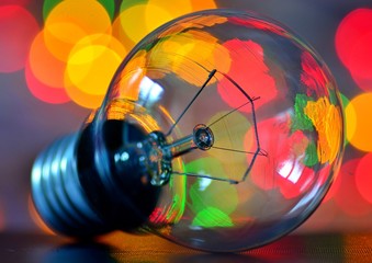 Incandescent electric lamp close-up against the background of bright garlands