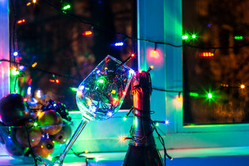 colored garland in a glass of champagne in the night the Windows in the run up to Christmas