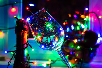 colored garland in a glass of champagne in the night the Windows in the run up to Christmas