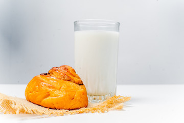 a glass of milk with bread and grains