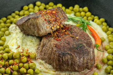 Beefsteak with green pepper sauce and peas