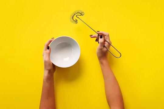 Female hands holding cooking equipment for meringue, sponge cake, biscuit baking. Whisk and white bowlI. Bakery, cooking, healthy homemade food concept. Copy space