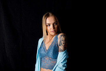 a studio shot of a young woman with tattoo