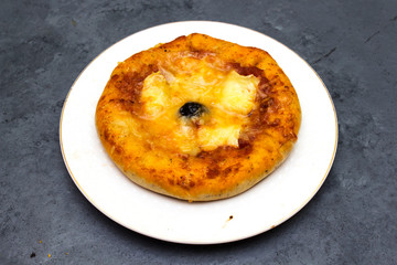 homemade arabic margarita mini pizza with  tomatoes, cheese, black olive, Thyme  on gray wooden background