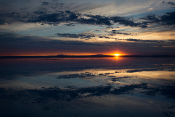 Fototapeta na wymiar Sunrise over Salar de Uyuni, Bolivia, with water reflection