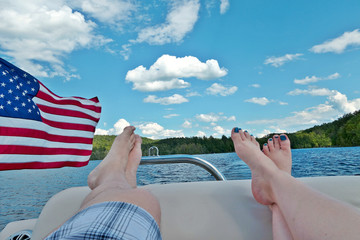WIth a glimpse of the American flag, two people relax on a boat - Powered by Adobe