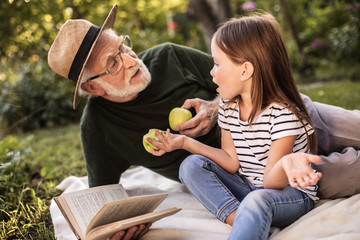 Grandfather with her preteen granddaughter on picnic
