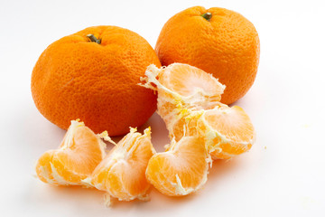 peeled and unpeeled tangerines on a white background