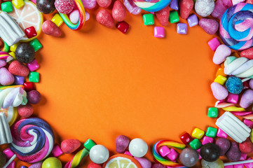 sweets are different on a black background, candy, gum, candy on a orange background