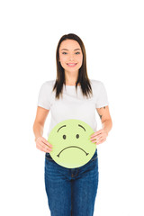 attractive girl holding green sign with sad face expression while looking at camera isolated on white
