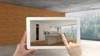 Augmented reality concept. Hand holding tablet with AR application used to simulate furniture and design products in an interior construction site, modern kitchen with island