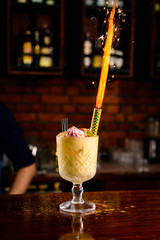 celebratory fire in a cocktail on the background of the bar, alcoholic birthday fireworks