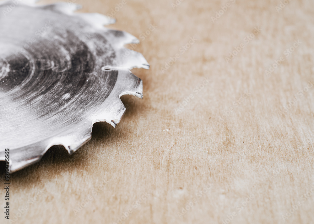 Sticker circular metal saw on the background polished plywood. carpentry workshop, work tools