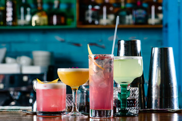 row of various colourfull alcoholic cocktails on bar counter in pup or restaurant