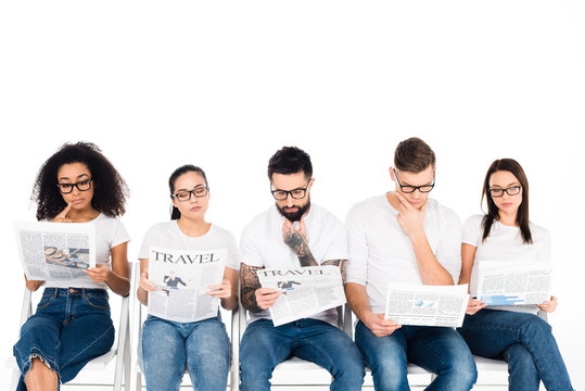 Multiethnic Group Of Young People In Glasses Reading Newspapers Isolated On White