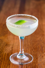 margarita cocktail closeup on bar counter in a margagita glass with lime