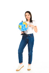 cheerful woman pointing with finger at globe isolated on white