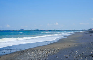 Oceanic coast with black volcanic sand on the island of Bali