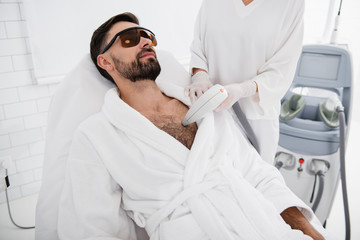 Bearded man wearing protective glasses during the laser procedure