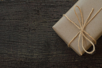 Simple eco friendly gift boxes package wrap with brown paper in old wooden table background, green present concept