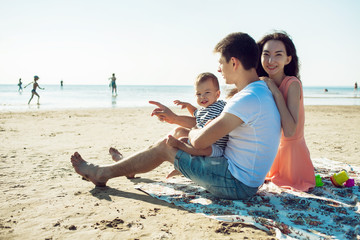 Fototapeta premium Cheerful multi ethnic family have a rest on a sea shore.