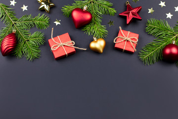 Festive Christmas background with fir branches, presents, decorations on black, copy space