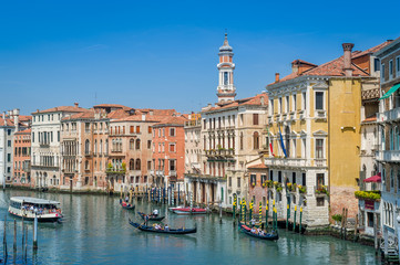 Fototapeta na wymiar Traditional gondolas and touristic boat at the Grande Channel of Venice.