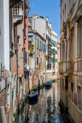 Obraz premium Mały kanał starego miasta w Wenecji z pięknymi refleksami na wodzie