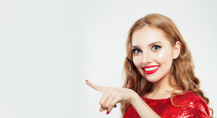 Young happy woman pointing finger on white background with copy space