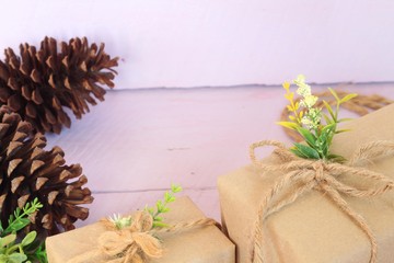 Gift box wrapped in recycled paper on pink background