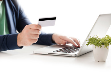 Man holding credit card and using laptop. Online shopping concept