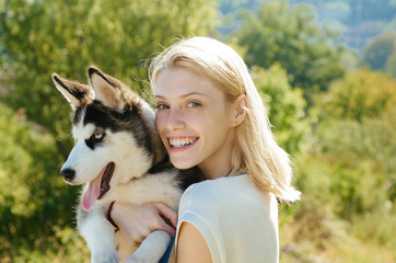 This girl loves her siberian husky. Sexy woman with dog pet on summer day. Happy girl hold pedigree dog. Happy dog owner play with family pet outdoor. Husky is for young at heart with smiling eyes