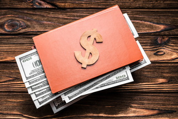 book, dollars on wooden background. business, Finance, currency, investments.