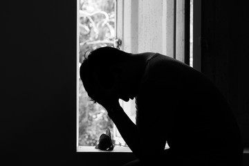 Sad man thinking and looking from windows with rose in valentines day.B&W style