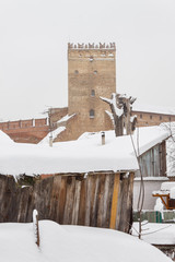 Old houses on the background of a medieval castle in winter